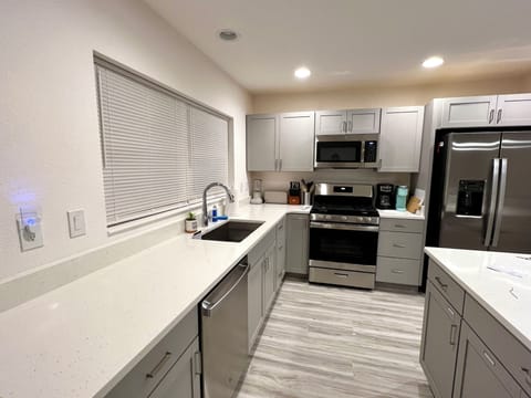 Large kitchen with island, quartz counters, gas range
