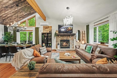 Gather in style in this inviting living space, where rustic charm meets modern comfort. With vaulted ceilings, elegant lighting, and forest views through every window, it’s the heart of the home — made for connection, laughter, and cozy nights in.