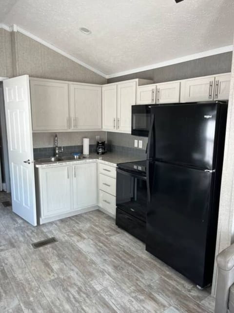 A clean, modern kitchen with a drip coffee maker, full stove/oven, and fridge, plus plenty of cabinet space—perfect for simple meals, morning coffee, and easy, relaxed stays.