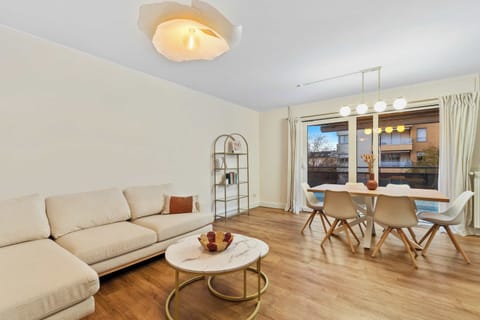 Comfortable living room featuring a spacious L-shaped sofa, soft lighting, and modern decor. A perfect place to unwind after a day exploring Luxembourg or working in nearby Kirchberg.