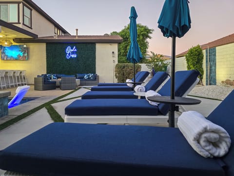 Expansive outdoor space with loungers, firepit & 75" Smart TV.