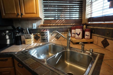 Lake House: Kitchen Details: Fully stocked for your convenience, the kitchen features a double stainless steel sink, tiled backsplash, and all the necessary utensils and small appliances for your stay.
