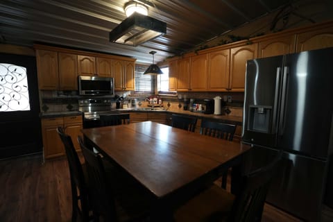 Lake House: Full Kitchen & Dining: Prepare your favorite meals in the fully equipped kitchen featuring stainless steel appliances and ample counter space. A large indoor dining table is perfect for family meals.