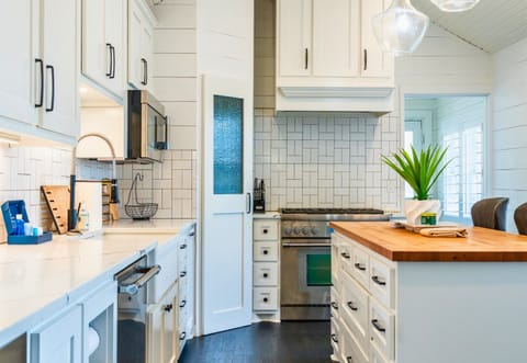 Chef-ready kitchen with premium appliances, farmhouse sink, and clean white cabinetry.
