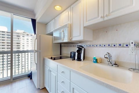 Enjoy ocean peeks from this bright beachside kitchenette, complete with full-size fridge, cooktop, microwave, and coffee maker—perfect for easy meals during your relaxing coastal stay.