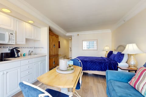 Inviting beach stay studio featuring a comfy bed, full kitchenette, and relaxed seating. Enjoy natural light and coastal comfort—perfect for unwinding after a day on the sand and surf.