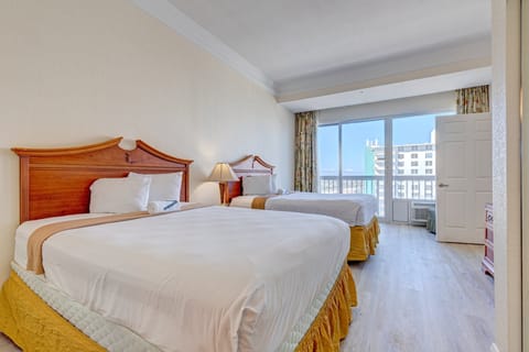 Spacious beachside room with two comfy beds, natural light, and balcony views—perfect for relaxing after a sun-filled day on the shore.