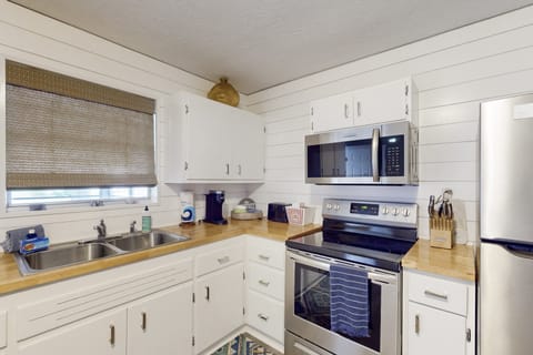 Clean, fully equipped kitchen with modern appliances, beach-inspired details, and ample counter space—perfect for preparing meals and snacks during your relaxing, carefree beach stay.