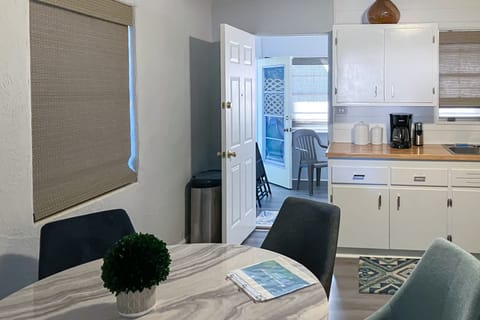 Bright, open kitchen and dining space with beach-inspired touches and easy outdoor access—perfect for quick meals and laid-back gatherings during your comfortable, carefree beach stay.