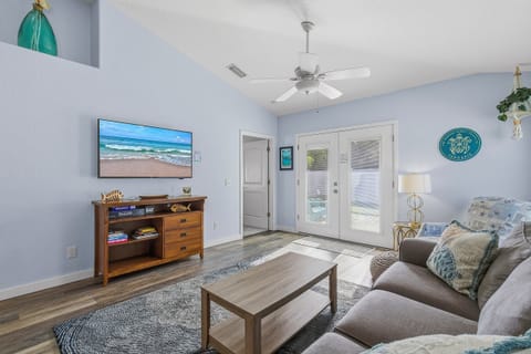 Airy coastal living room featuring beach-inspired décor, comfy seating, and plenty of natural light. The perfect space to unwind after a day at the beach during your relaxing seaside vacation stay.
