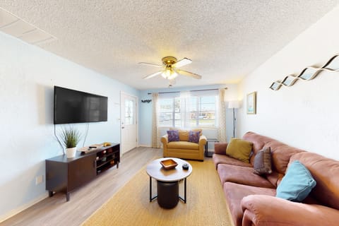 Bright and inviting beach stay living space featuring plush seating, smart TV, and natural light. Relax after a day by the shore in this comfortable coastal retreat—perfect for your seaside vacation getaway just minutes from the beach.