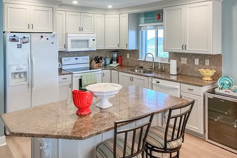 Fully equipped coastal kitchen with granite counters and spacious island—perfect for cooking during your beach stay. Bright, inviting, and stocked with essentials for a relaxing ocean getaway.