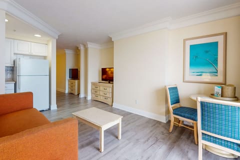 Inviting beach-stay living space featuring comfy seating, dining area, and light coastal décor. Relax after a day on the sand in this spacious, sunlit retreat.