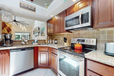 Bright, beach-ready kitchen featuring stainless appliances, granite counters, and plenty of space to prepare meals during your coastal getaway. Perfect for cooking and gathering after a day by the shore.