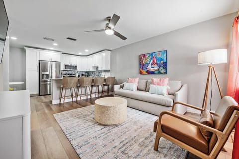 Bright, modern living space with a sleek kitchen, plush seating, and warm décor. Enjoy stainless appliances, a cozy lounge area, and stylish touches throughout—perfect for relaxing or gathering in comfort and style.