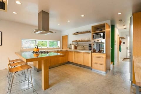 Our open-concept kitchen with oven, gas range,  microwave, coffee maker, bar seating and dining table.