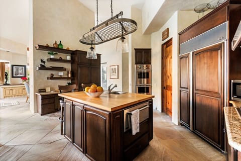 A beautifully appointed kitchen with rich wood tones and a statement island, designed for effortless entertaining and everyday comfort.