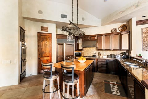 A chef-inspired kitchen with warm wood finishes and a central island—perfect for morning coffee, casual meals, and gathering with friends.