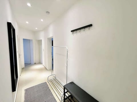 Der lange Eingangsbereich bietet eine Sitzbank, eine Jackenhalterung und einen Körperspiegel.