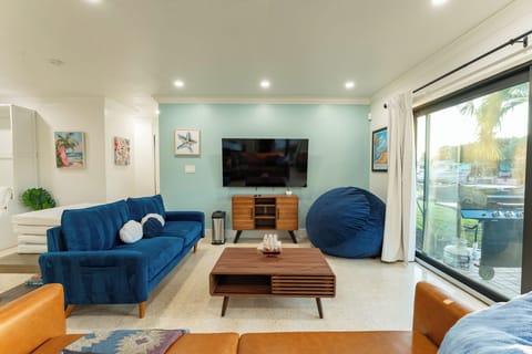 Cozy living room with smart TV, bean bag, and direct backyard access.