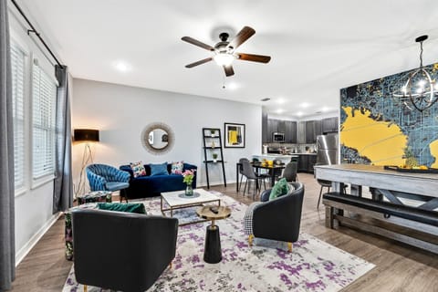 A chic open-concept living room designed for gatherings, offering a cozy atmosphere with elegant furniture and warm lighting.