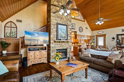 Living Area | Open-Concept Great Room with Stone Fireplace & Loft Overlook