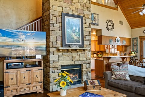 Living Area | Open-Concept Great Room with Stone Fireplace & Loft Overlook