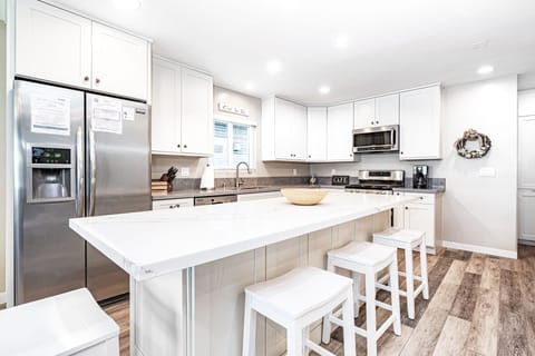 The kitchen features a large island with barstool seating and brand new appliances.