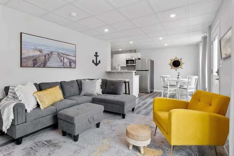 Comfortable living room with couch and chair that is open to the kitchen and dining area.