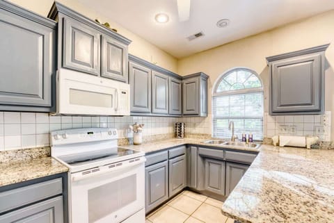 Fully equipped kitchen with granite counters, white appliances and all the cookware needed to whip up family feasts.