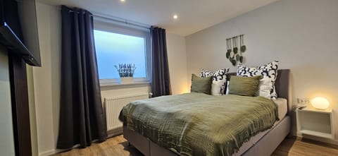 Bedroom with TV and box spring bed