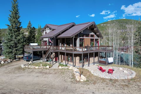 A view of the house with a fire pit, just look at that wrap around deck!