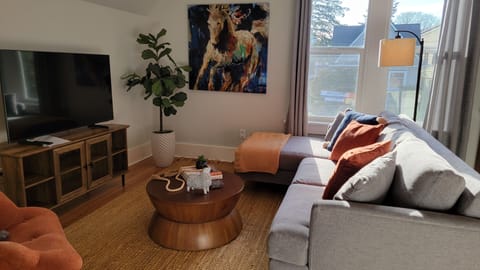 Relaxing living room with plenty of seating and light, and large tv. 