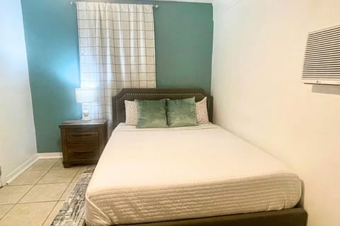 A serene bedroom with a ceiling fan and air-conditioning, perfect for unwinding after a busy day.