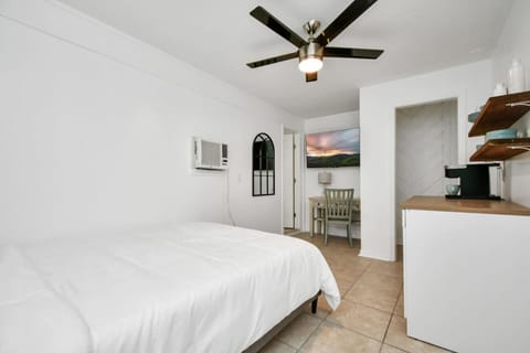 A serene bedroom with a ceiling fan and air-conditioning, perfect for unwinding after a busy day.
