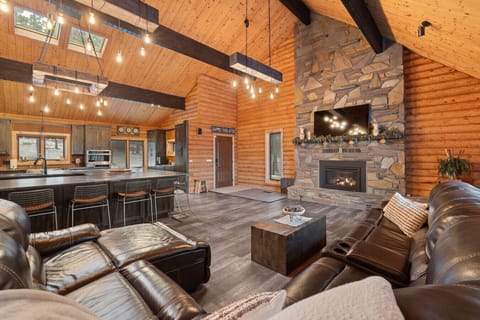 Escape to our breathtaking log cabin with a two-story stone fireplace, expansive open-plan living, and an impressive dining area built for family and friends!
