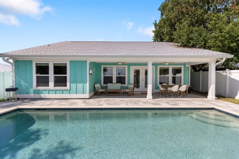 Dive into your private oasis with this sparkling pool and charming turquoise cottage, perfect for sunny days and poolside relaxation.