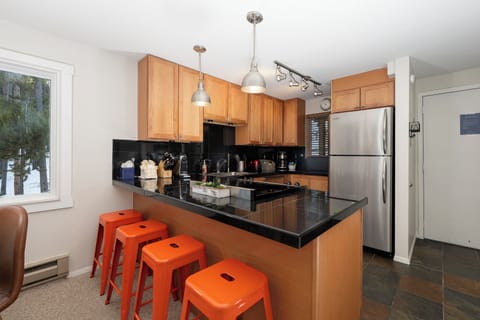 Your modern kitchen invites culinary adventures with sleek granite counters, warm wood cabinets, and a breakfast bar perfect for morning coffee.