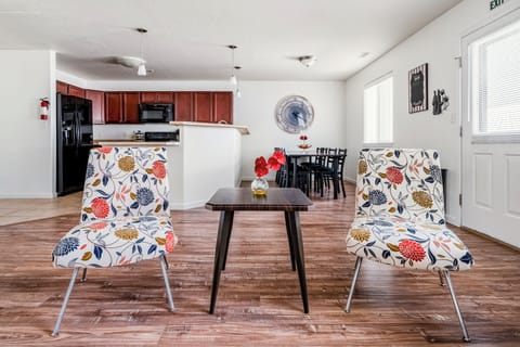 Step into your bright, open living space where cheerful floral chairs invite you to relax.
