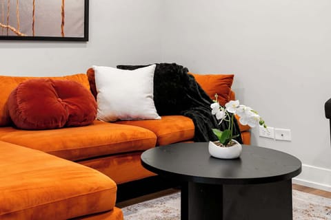 Vibrant living space w/ bold orange sofa for unwinding
