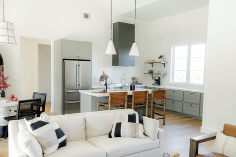 Sunlit open kitchen with island seating and vaulted ceiling charm.
