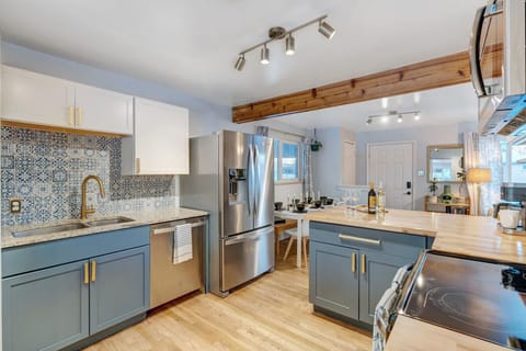 This beautifully remodeled kitchen has stainless steel appliances, butcher block counters, and open flow.