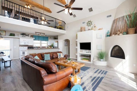 Relax in a thoughtfully designed living area featuring comfy chairs, elegant décor, and soaring ceilings, offering a spacious and inviting atmosphere.