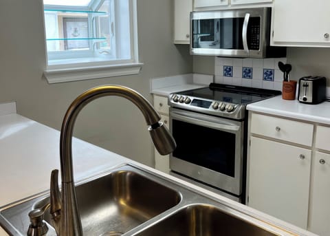 Kitchen with greenhouse window, microwave, electric stove oven and toaster