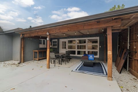 Covered patio with a dining table for six, plus fun outdoor games like corn hole