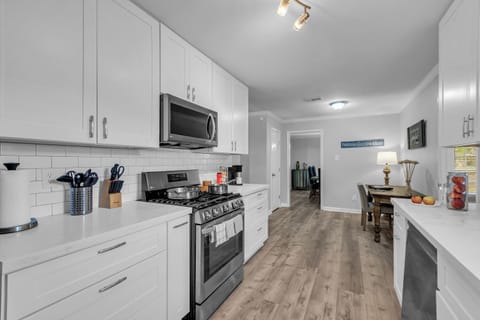 Stainless kitchen with stove, fridge, dishwasher, microwave, and coffee station.