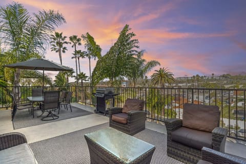 Spacious rooftop deck with lounge seating, dining table, and sunset views.