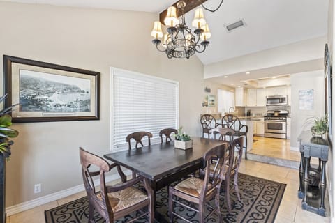 Spacious dining area with seating for six, flowing into the fully stocked kitchen.