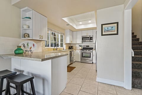Bright, fully equipped kitchen with granite countertops and modern appliances.