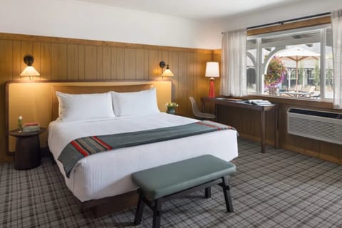 Unwind in a sunlit room with cozy bed and views.